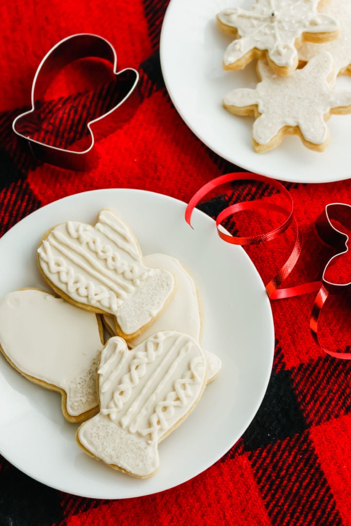 Sugar Cookies on a white round plate, on red plaid background.