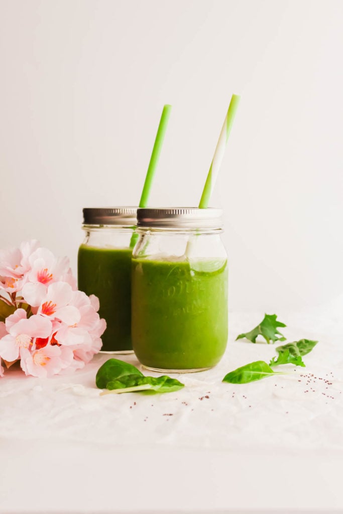 Jars of Everyday Green Smoothie with green and white straws.