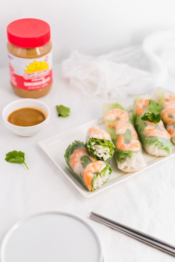 Vietnamese Salad Rolls on white rectangular plate with SunButter Dipping Sauce in small bowl, SunButter jar in background.