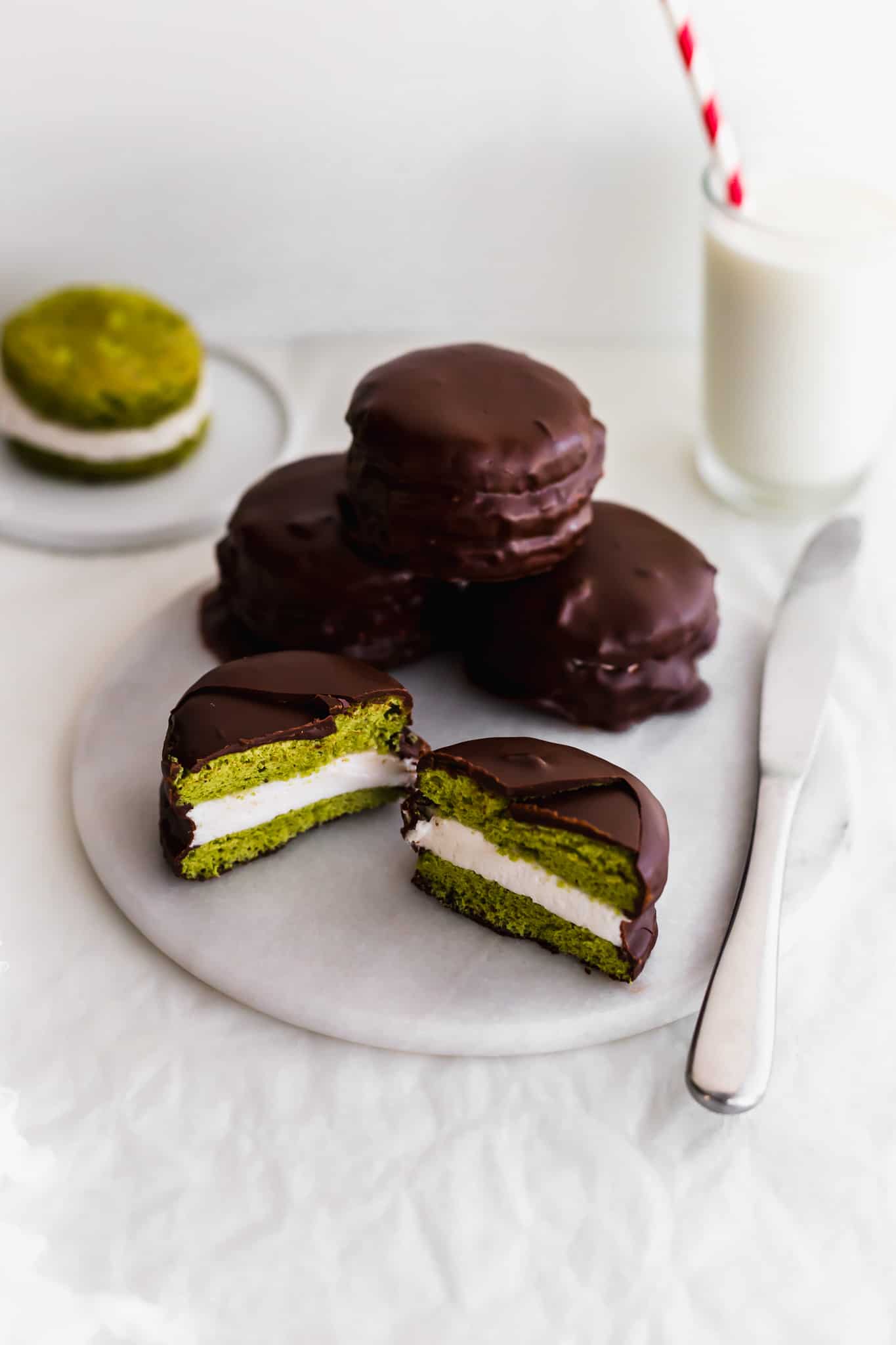 A side shot of the Korean snack choco pies. The choco pie is sliced in half to show the green matcha center. 