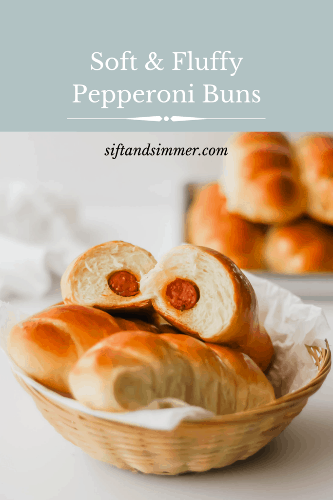 A basket of pepperoni buns with a bun cut in half to reveal the interior, tray of buns in background with text overlay.