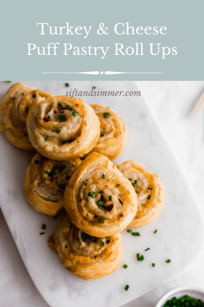 A stack of ham and cheese puff pastry scrolls topped with chives on marble, with text overlay.