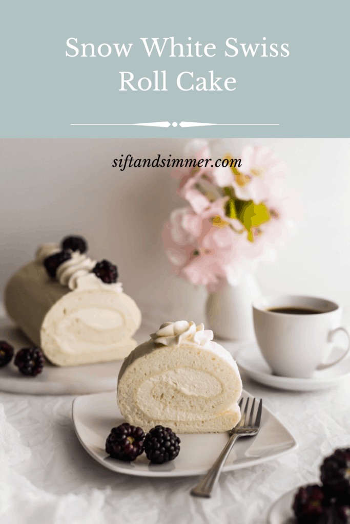 Slice of white roll cake on a plate with blackberries and fork.