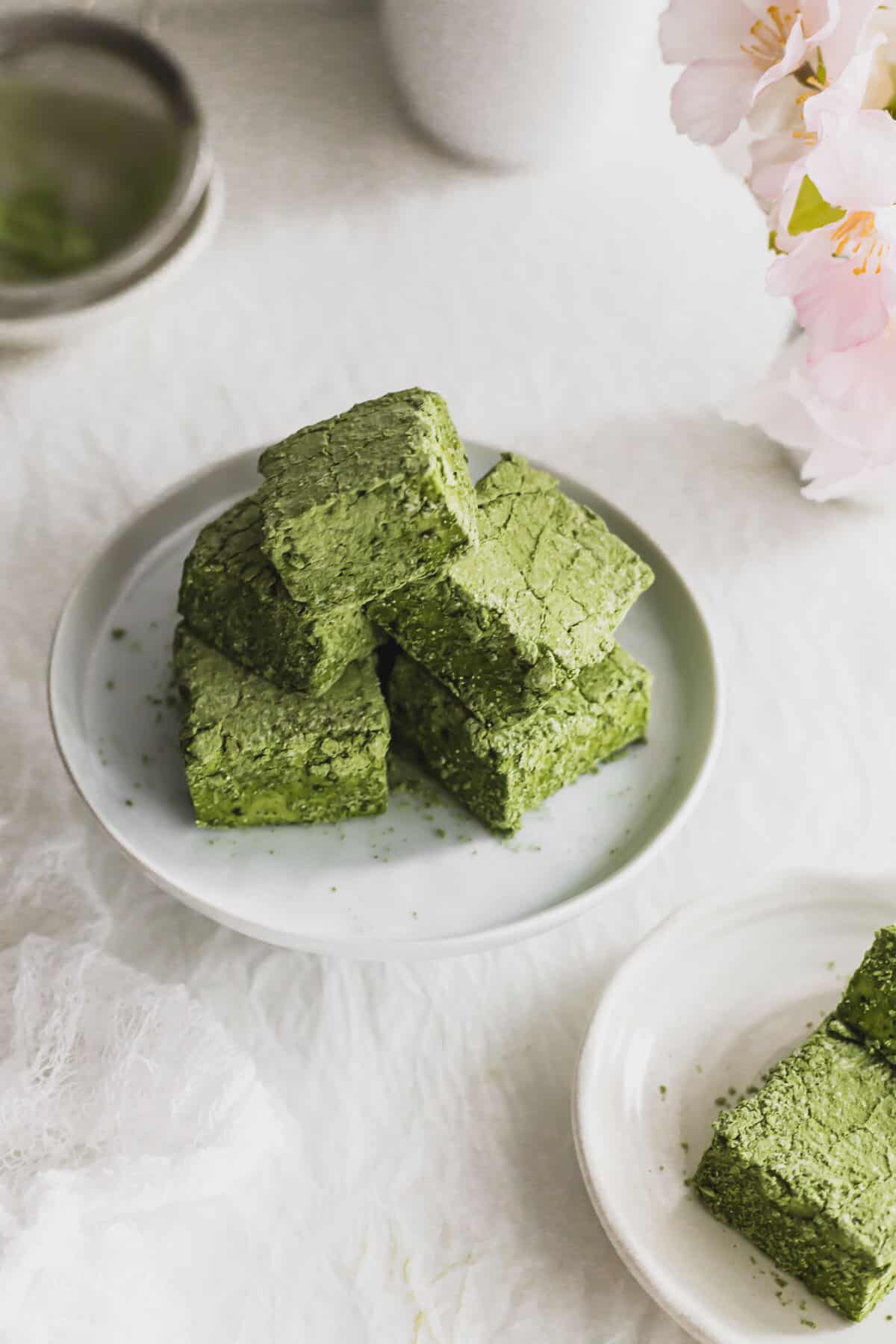 Pile of cut Matcha marshmallows on a plate.