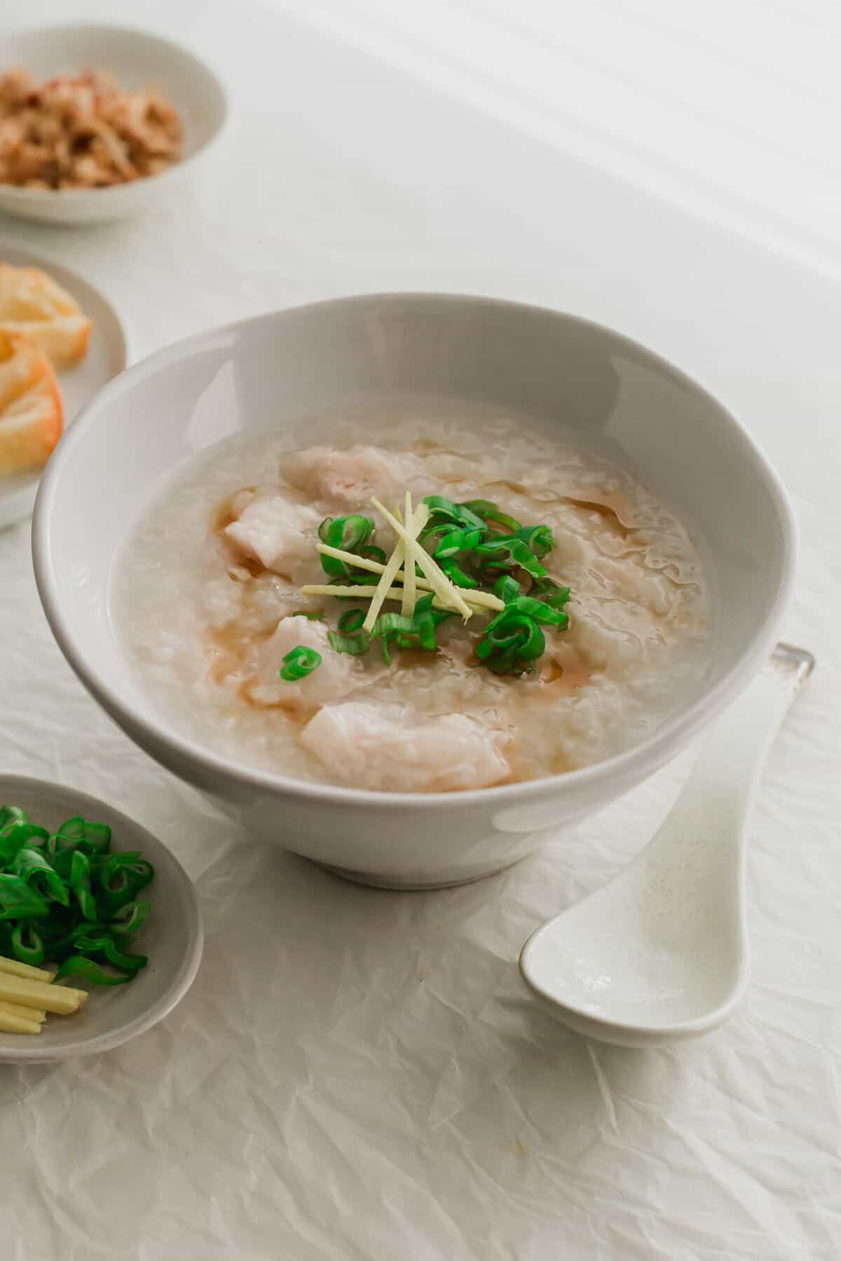 Chicken congee in a white bowl.