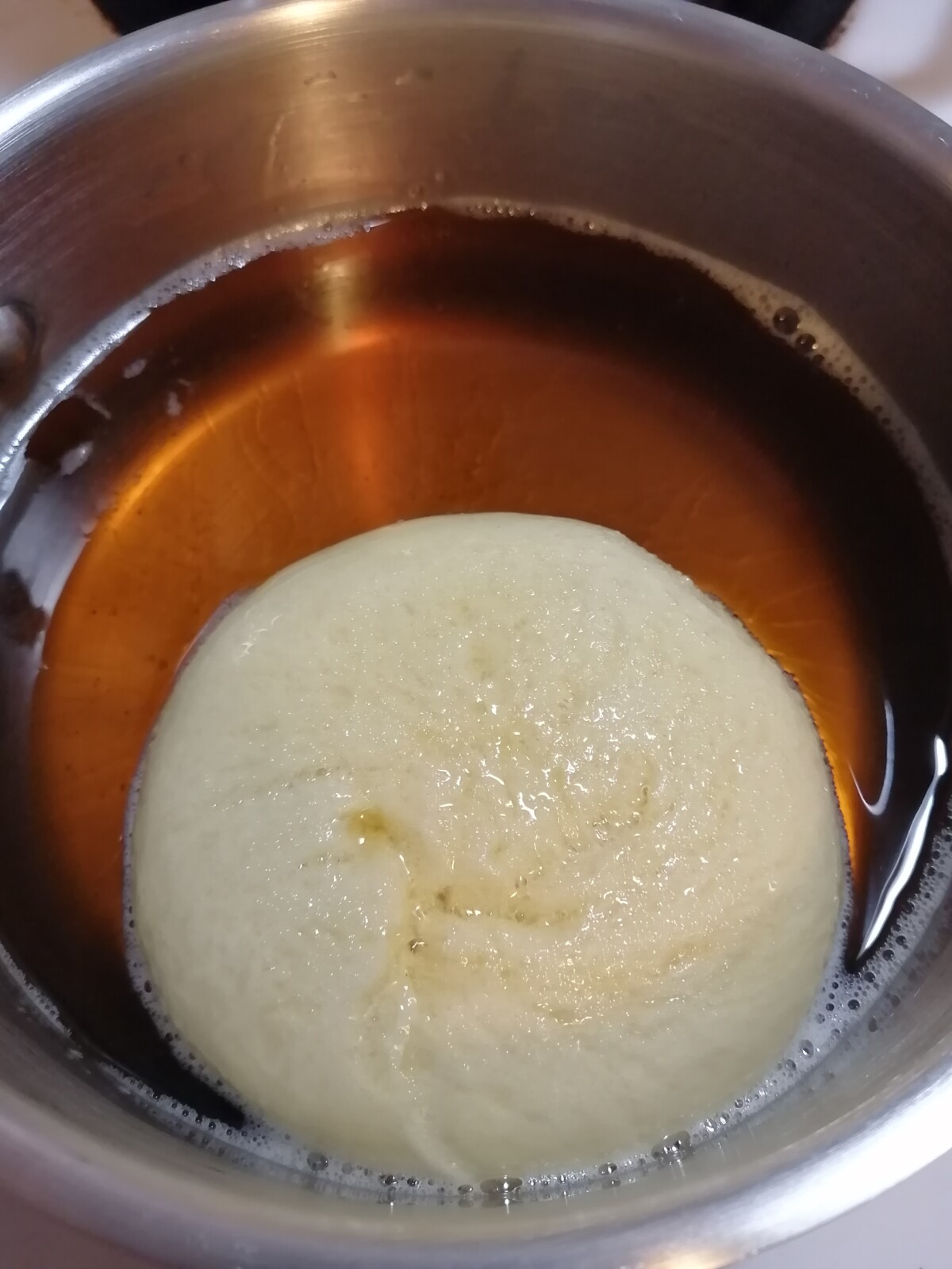 Doughnut in frying oil.