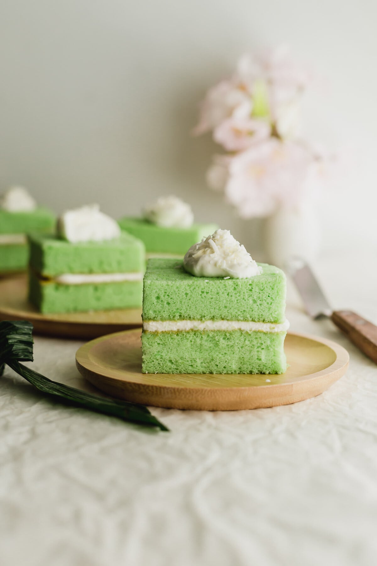 Pandan coconut cream cake on a bamboo plate.