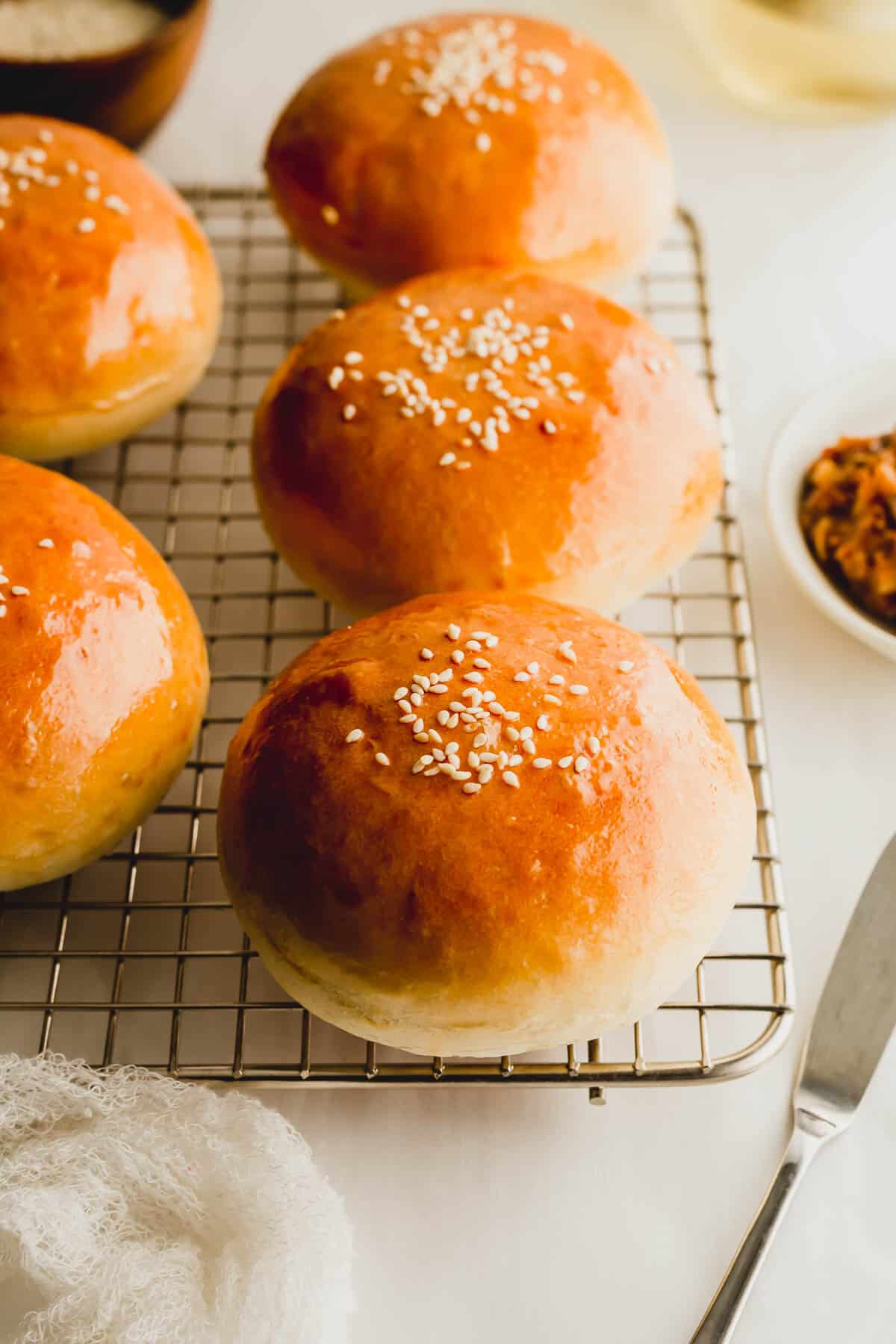 Baked Chinese BBQ pork buns on a wire rack.