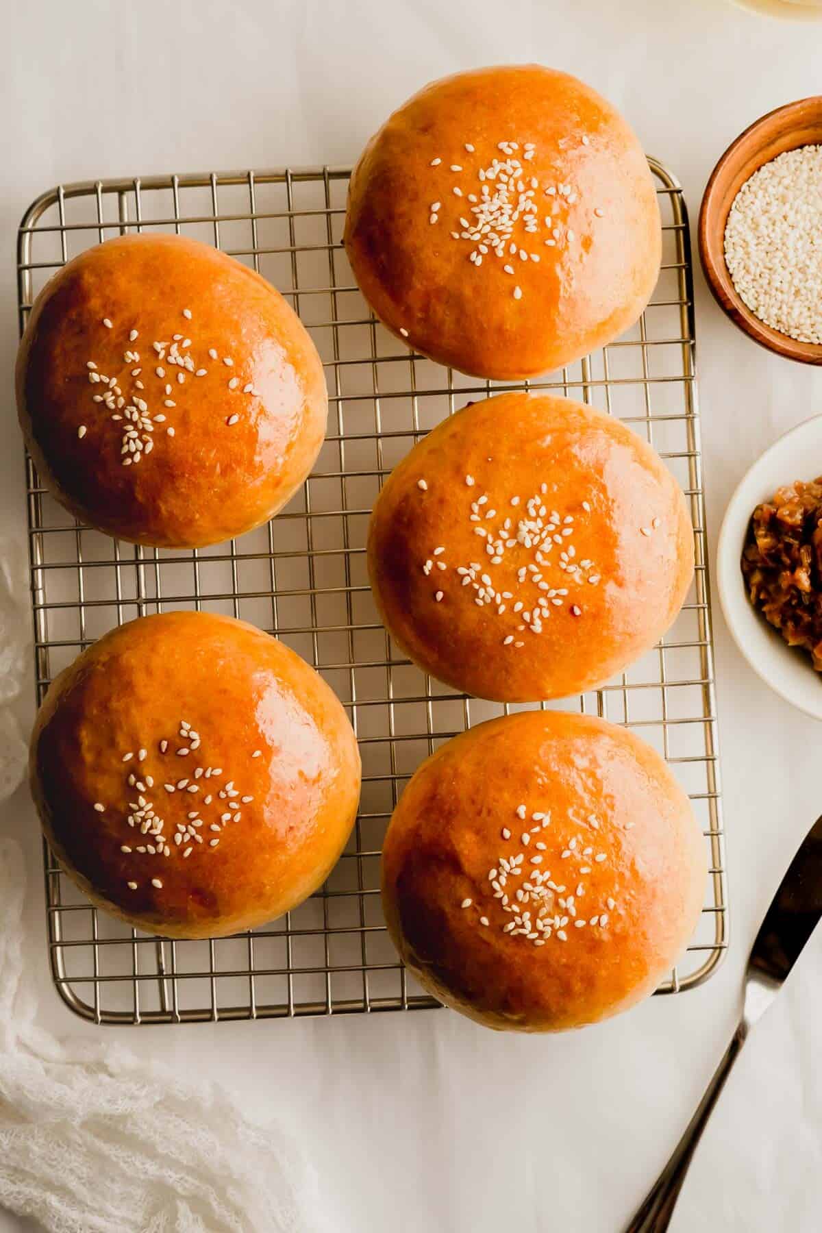 Overhead shot of baked Chinese BBQ pork buns on a wire rack.