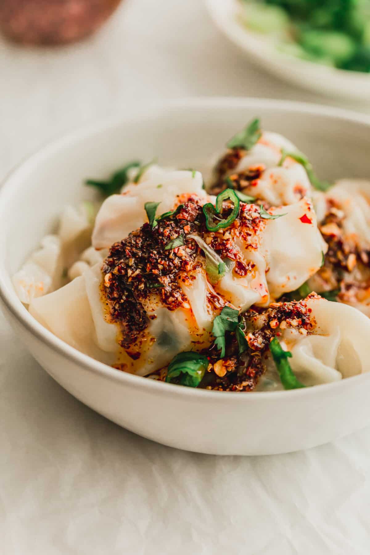 Close up of a bowl of wontons in white ceramic bowl
