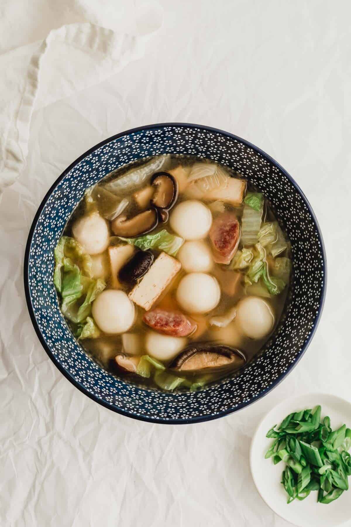 Savory tang yuan soup in a blue bowl.