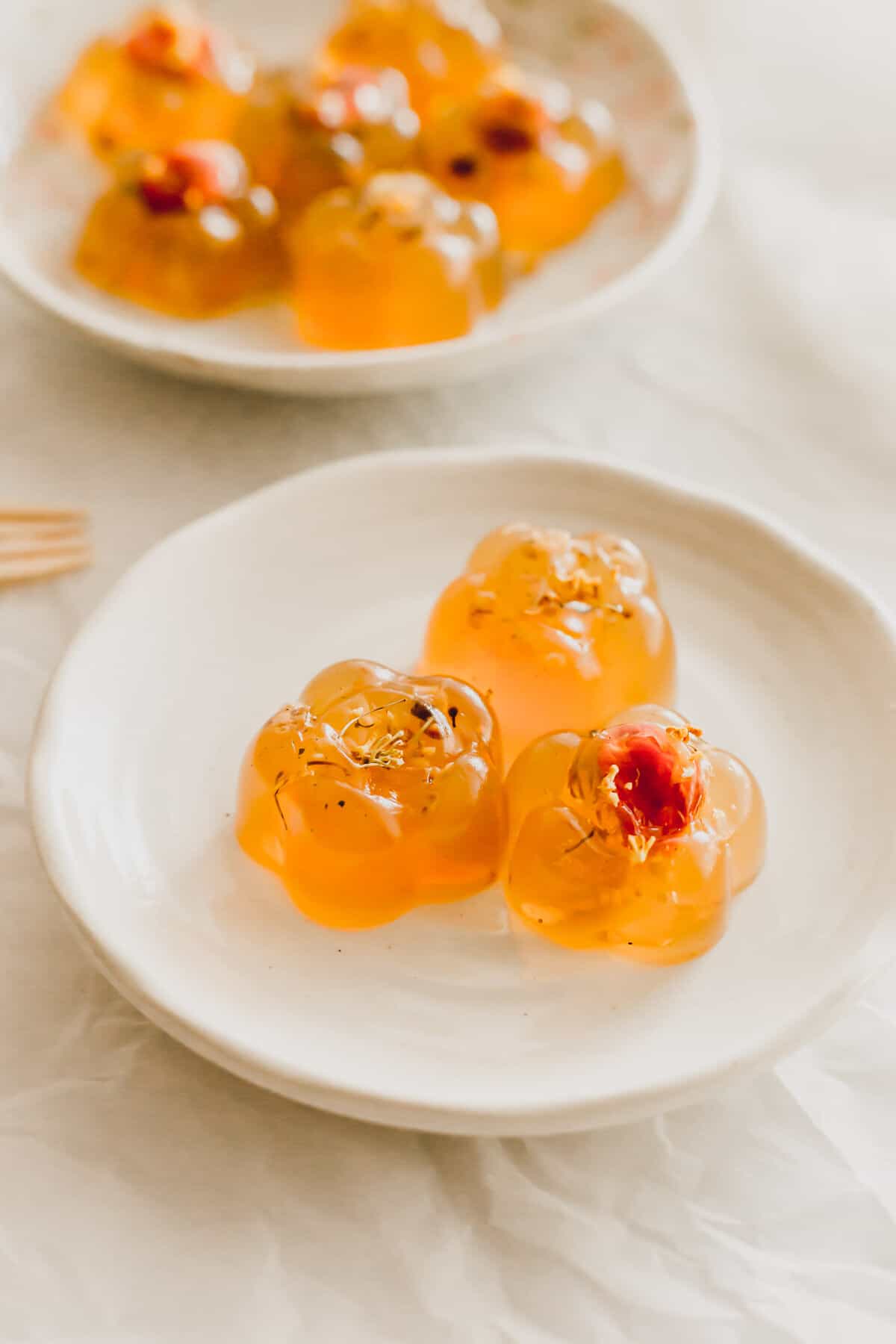 Osmanthus flower jellies on a white plate.