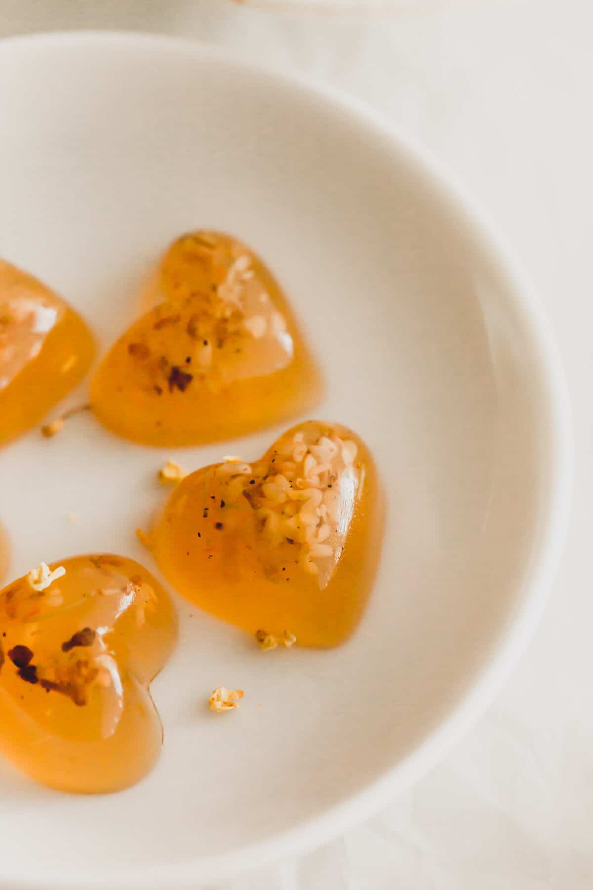 Heart-shaped osmanthus jellies on a white dish.