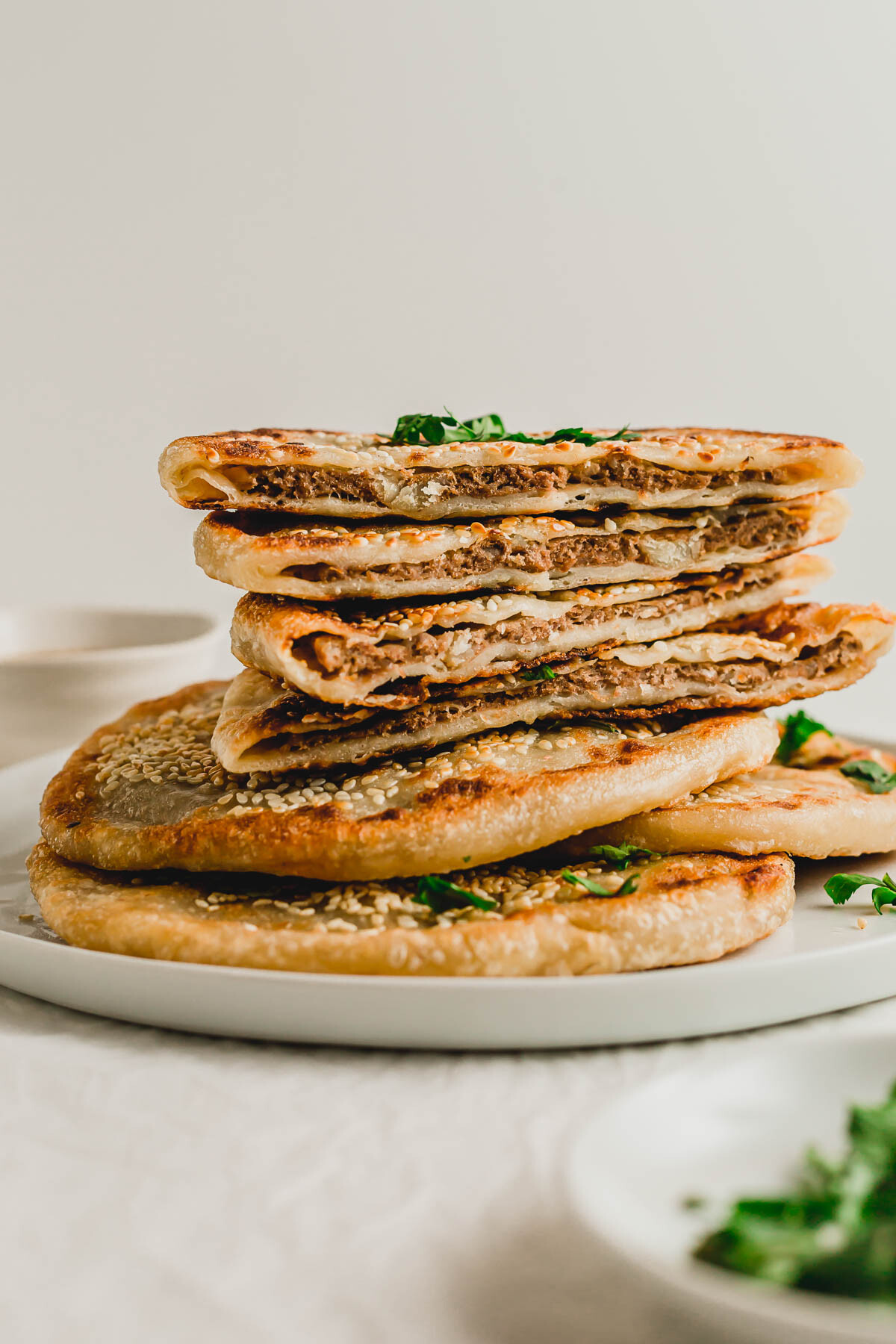 Cut, crispy Chinese beef pancakes piled high on a beige plate.