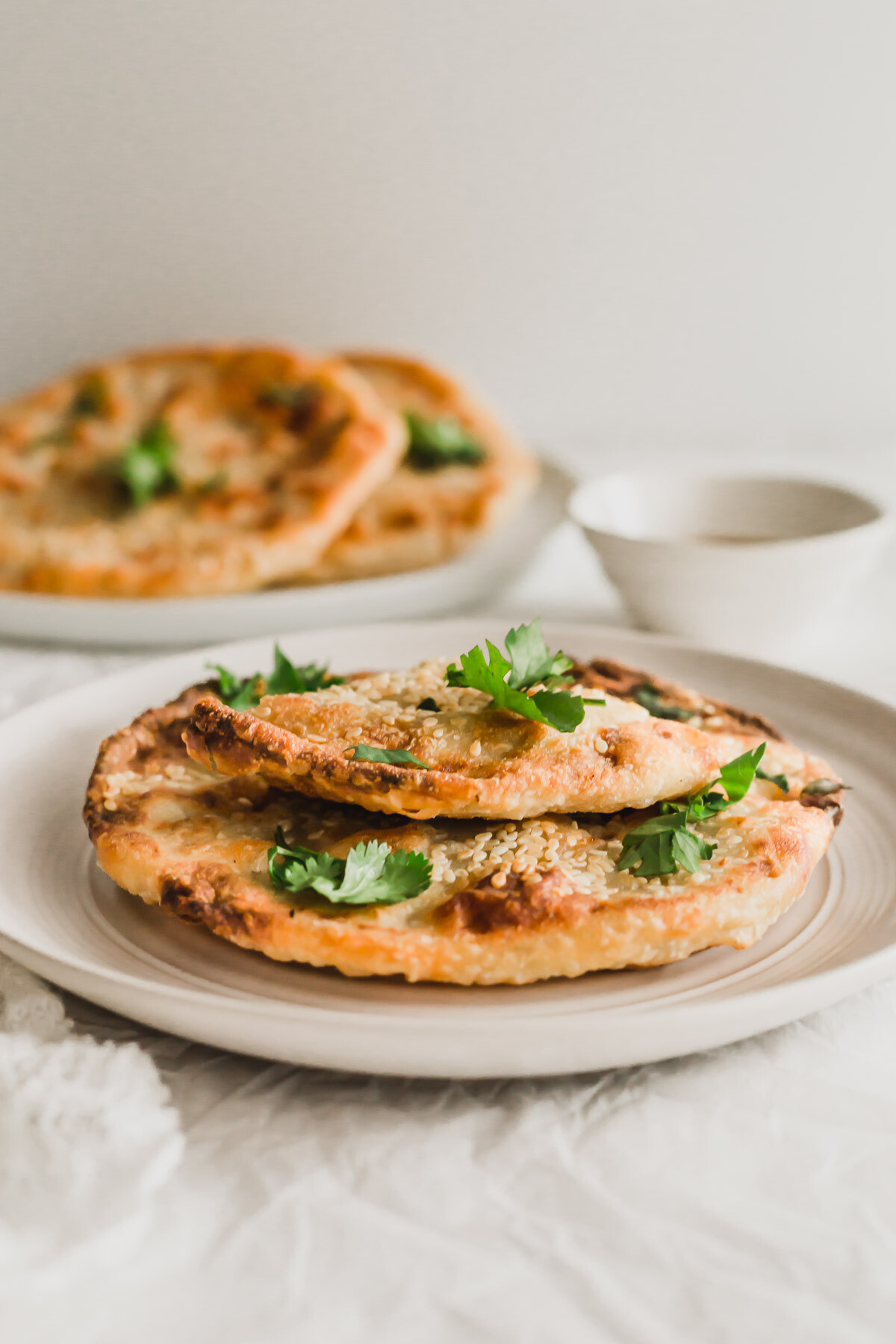 Cut, crispy Chinese beef pancakes on a beige plate.