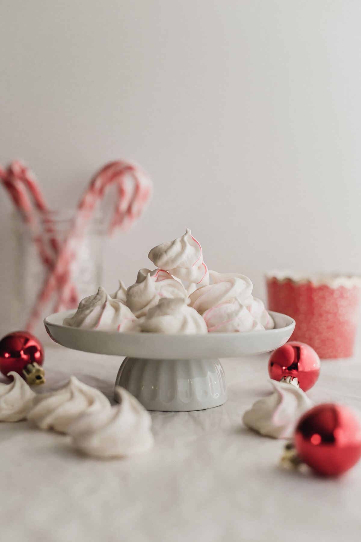 Meringues piled on a white mini cake stand.