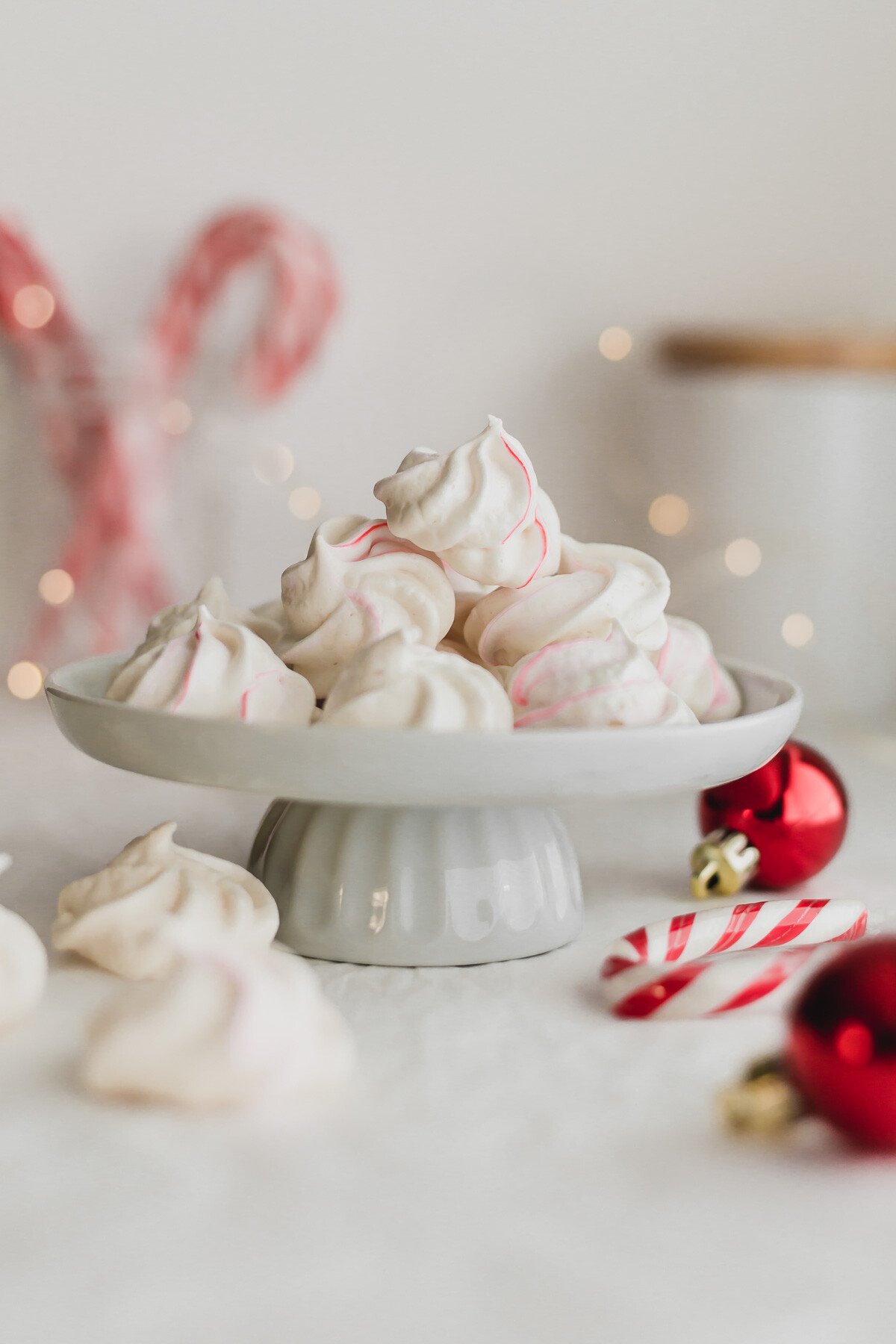 Meringues piled on a white mini cake stand.
