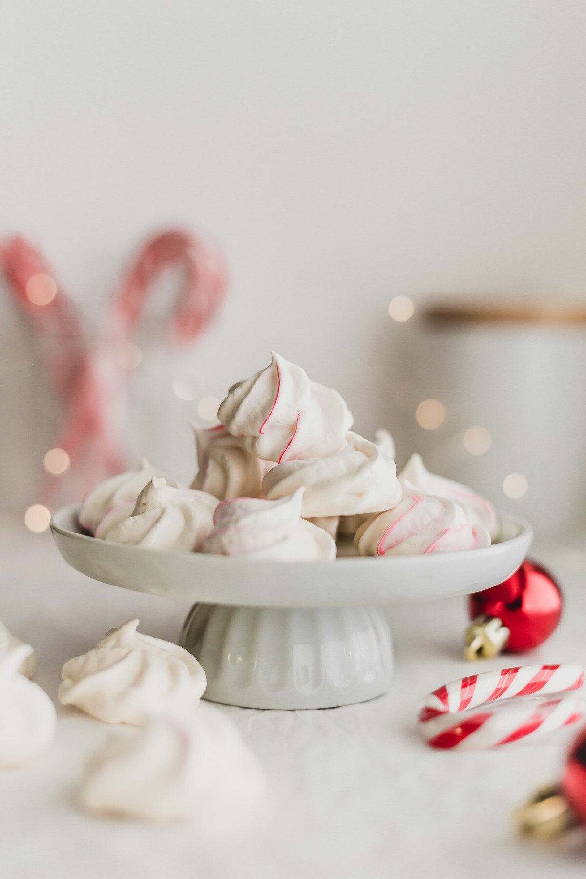 Meringues piled on a white mini cake stand.