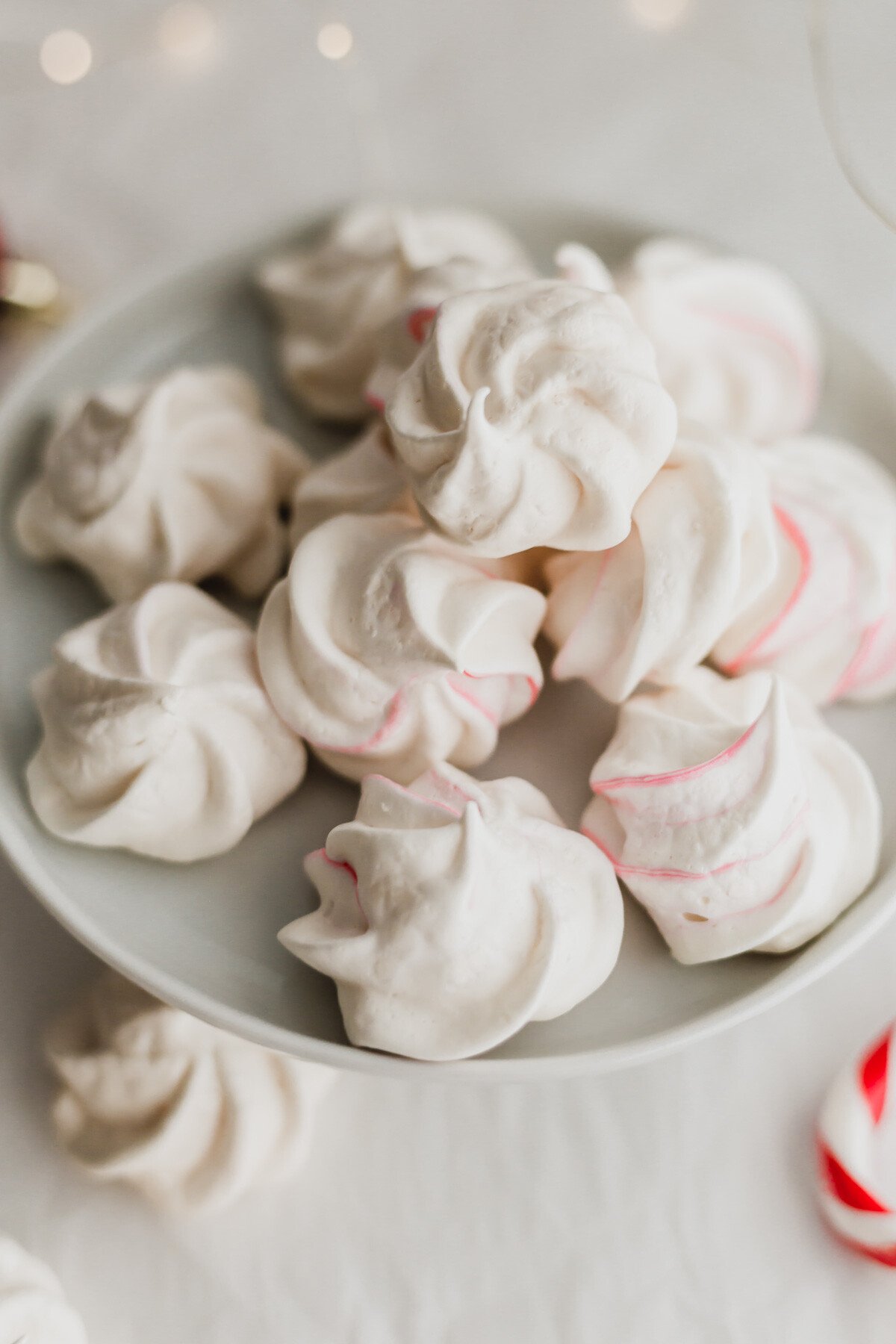 Peppermint meringues on a white cake stand.