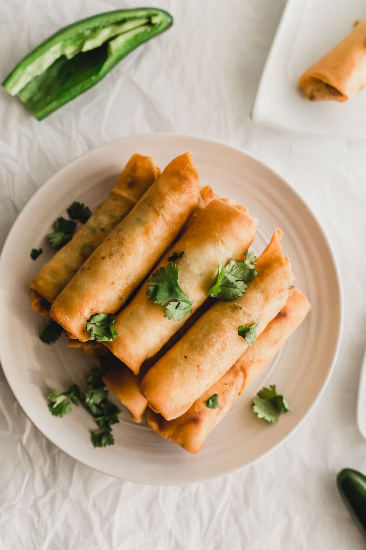 Jalapeno chicken egg rolls on a round plate.