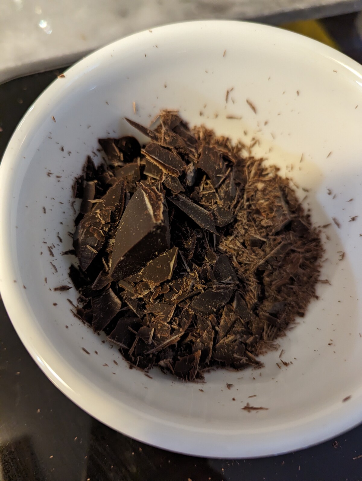 Shaved chocolate in a white bowl.