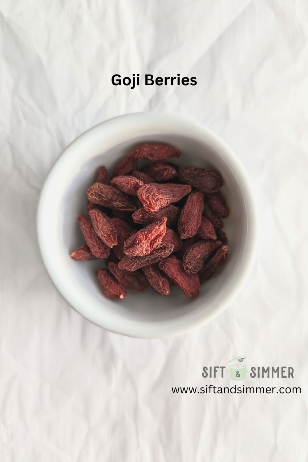Dried goji berries in a white bowl, with text overlay.