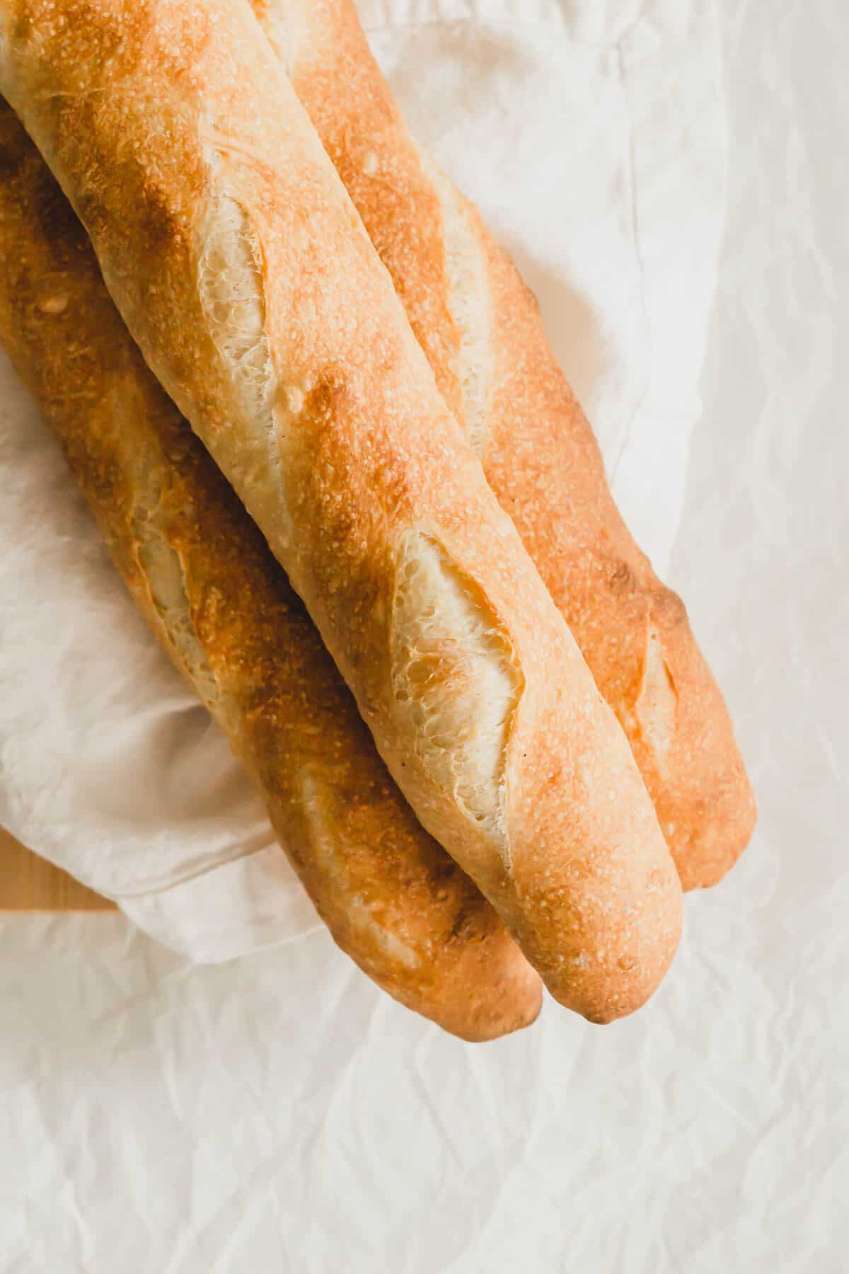 3 baguettes on a board with linen.