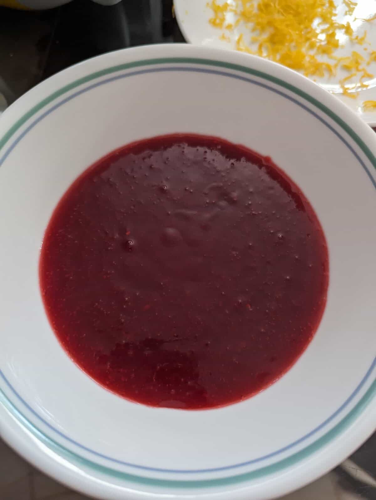 Raspberry coulis in a white bowl.