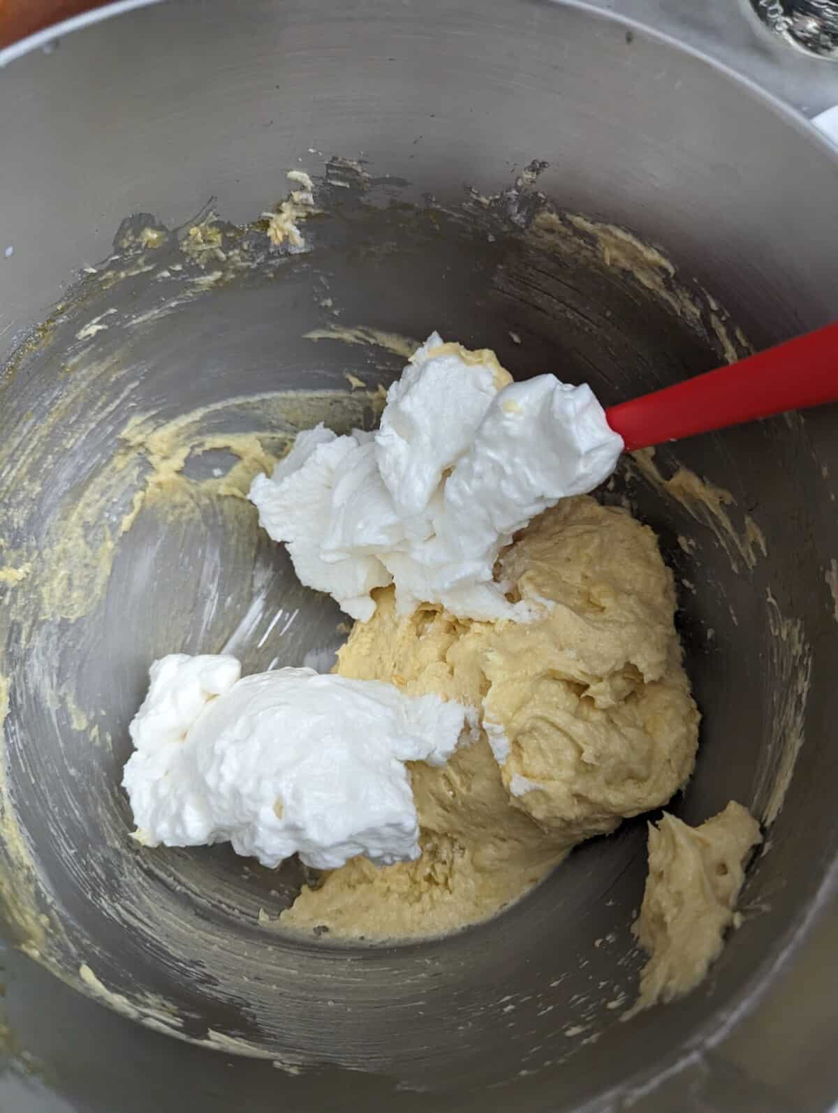 Folding whipped egg whites into butter mixture.