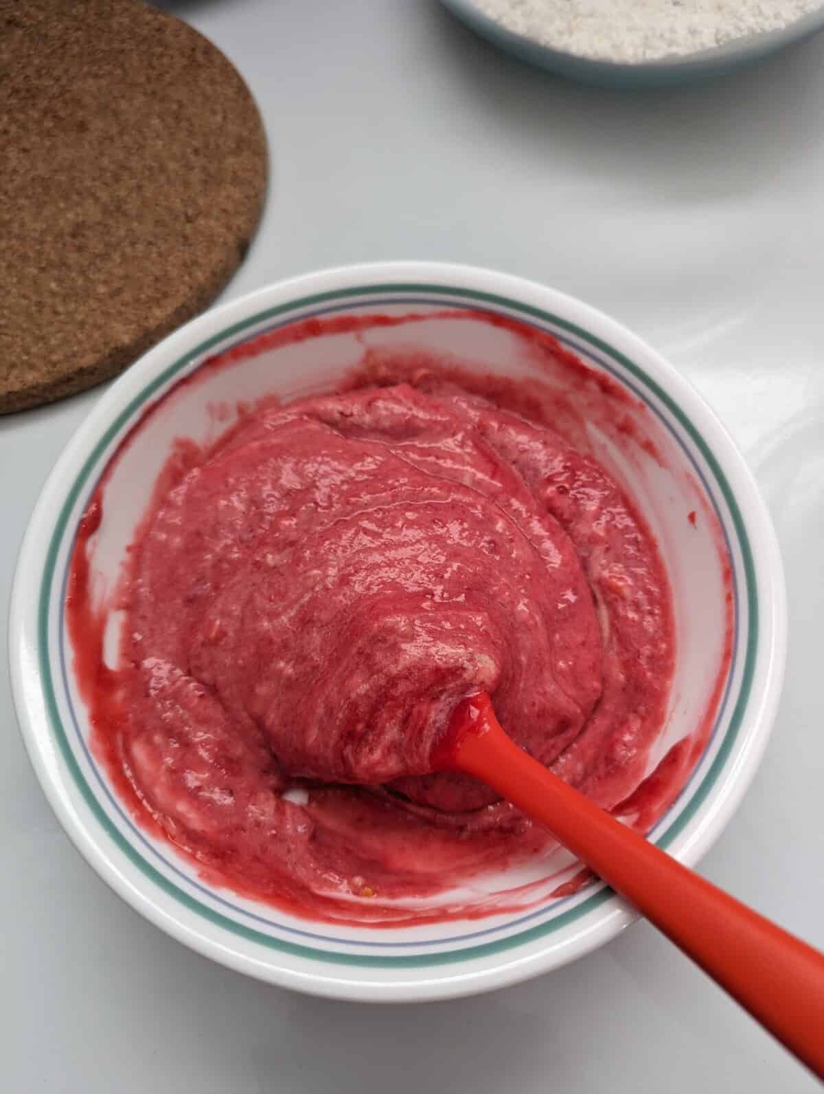 Raspberry cake batter folded mixture in a white bowl.