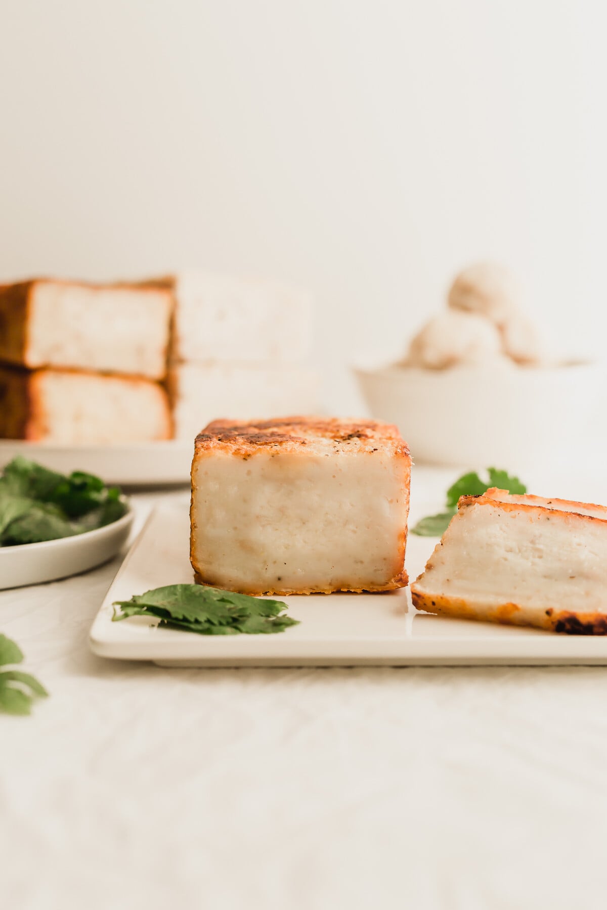 A block of Chinese fish cake on a square white plate.