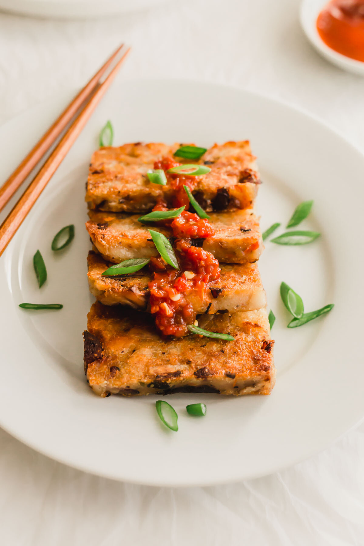Slices of pan-fried Chinese taro cake on white plate.