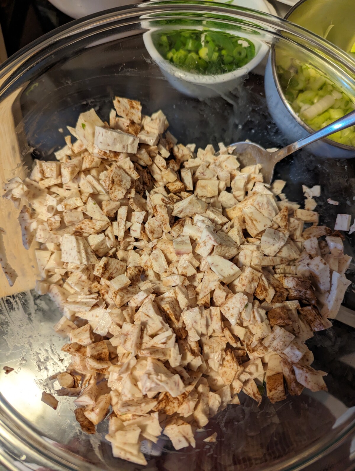 Taro mixed with the spices in a glass bowl.