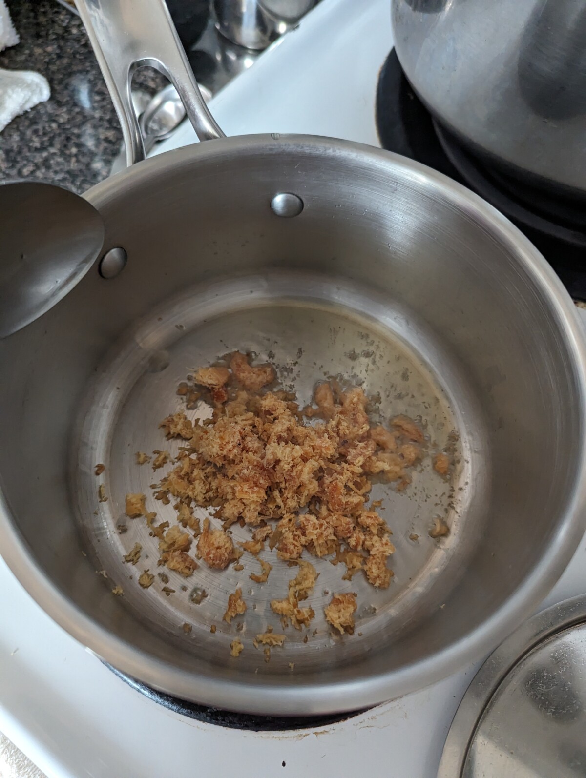 Frying up shrimp in oil in a metal pot.