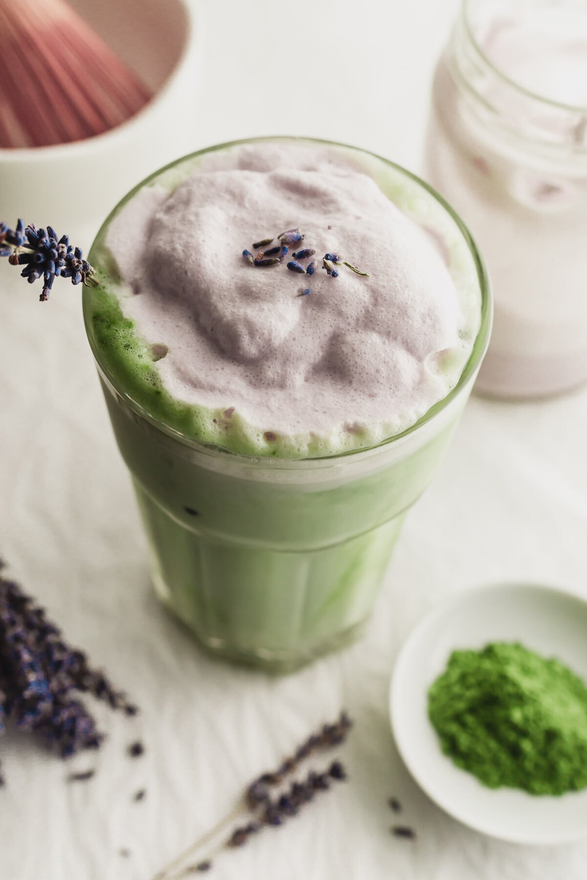 Close up of a glass of lavender cream matcha tea latte.