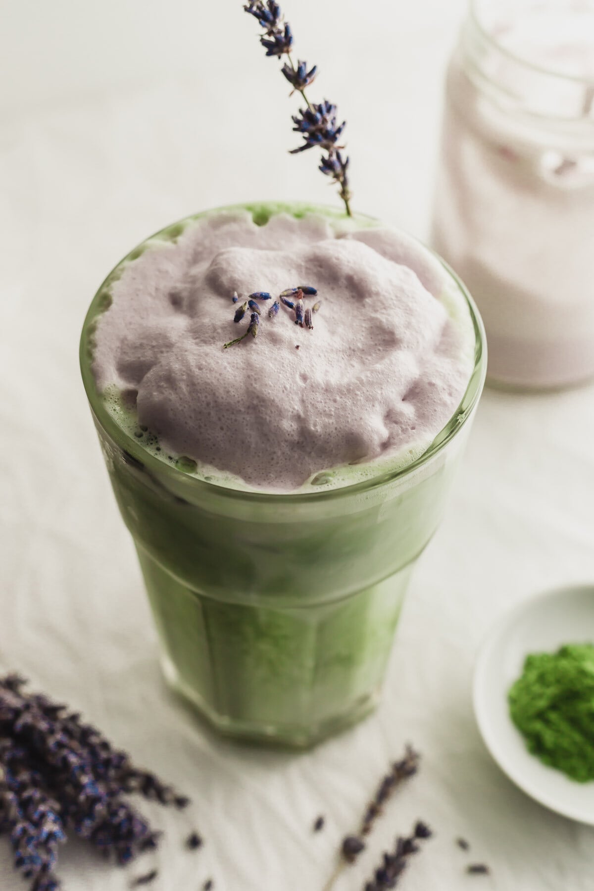 Close up of a glass of matcha latte with lavender cream cold foam.