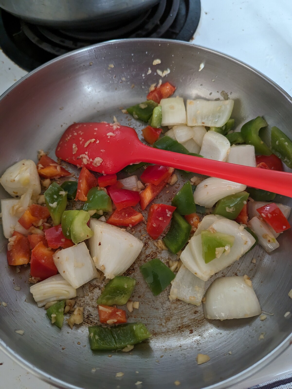 A frying pan with sauteed veggies.