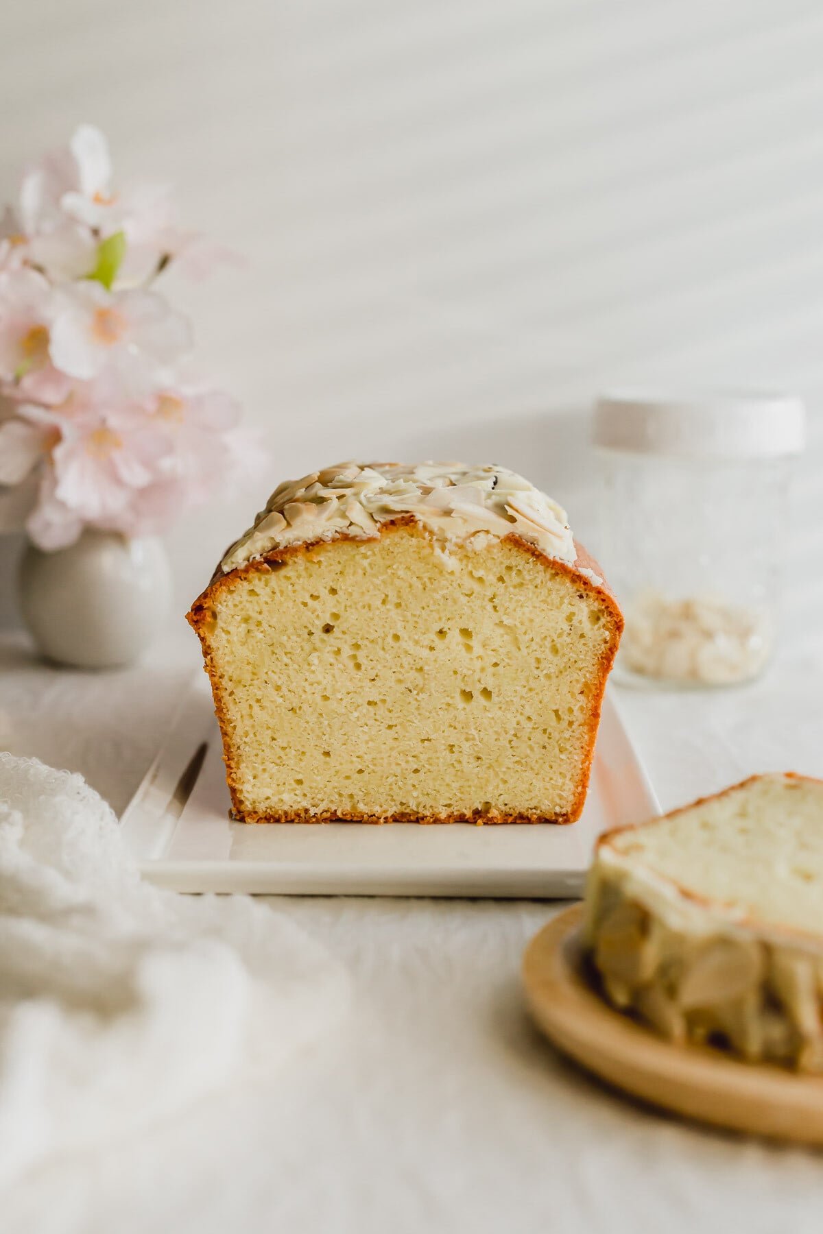 Sliced almond pound cake on a white rectangular plate.