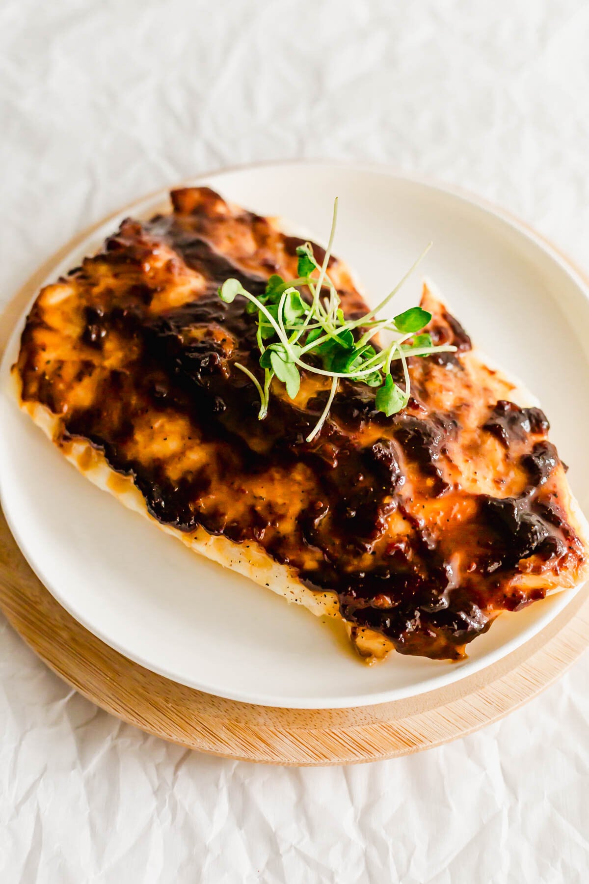 Hoisin glazed cod on a white plate, with fork.