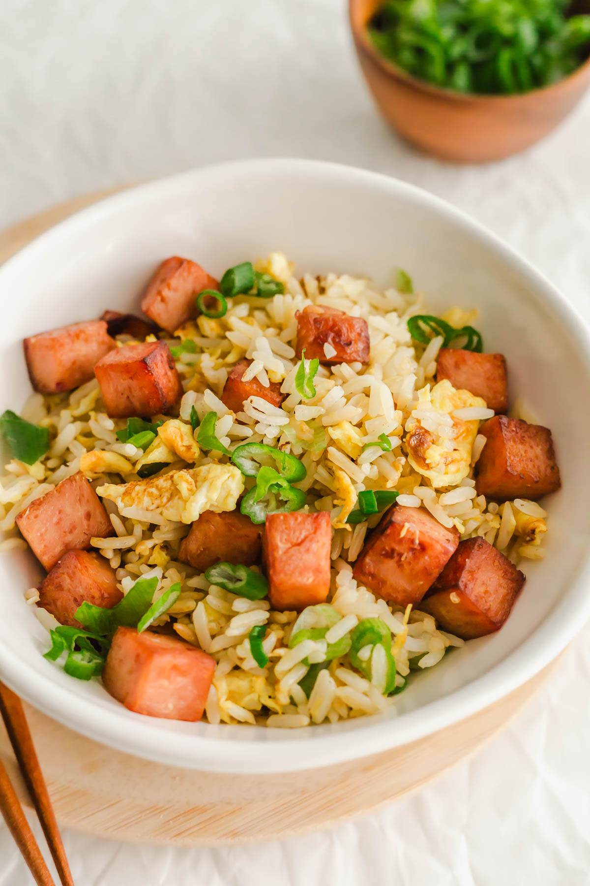 Close up of Spam fried rice in a white bowl.