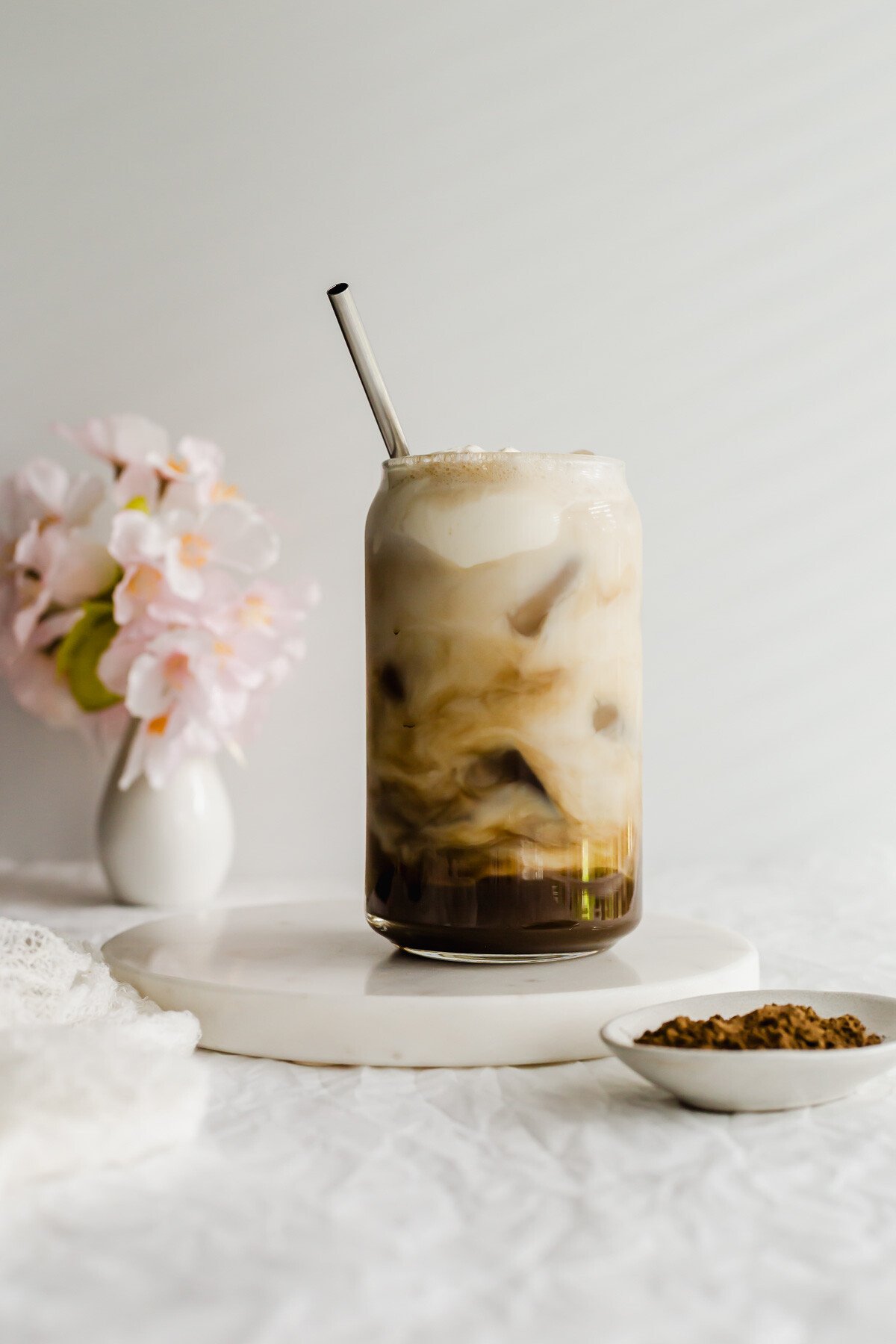 Iced Hojicha Latte in a glass with metal straw.