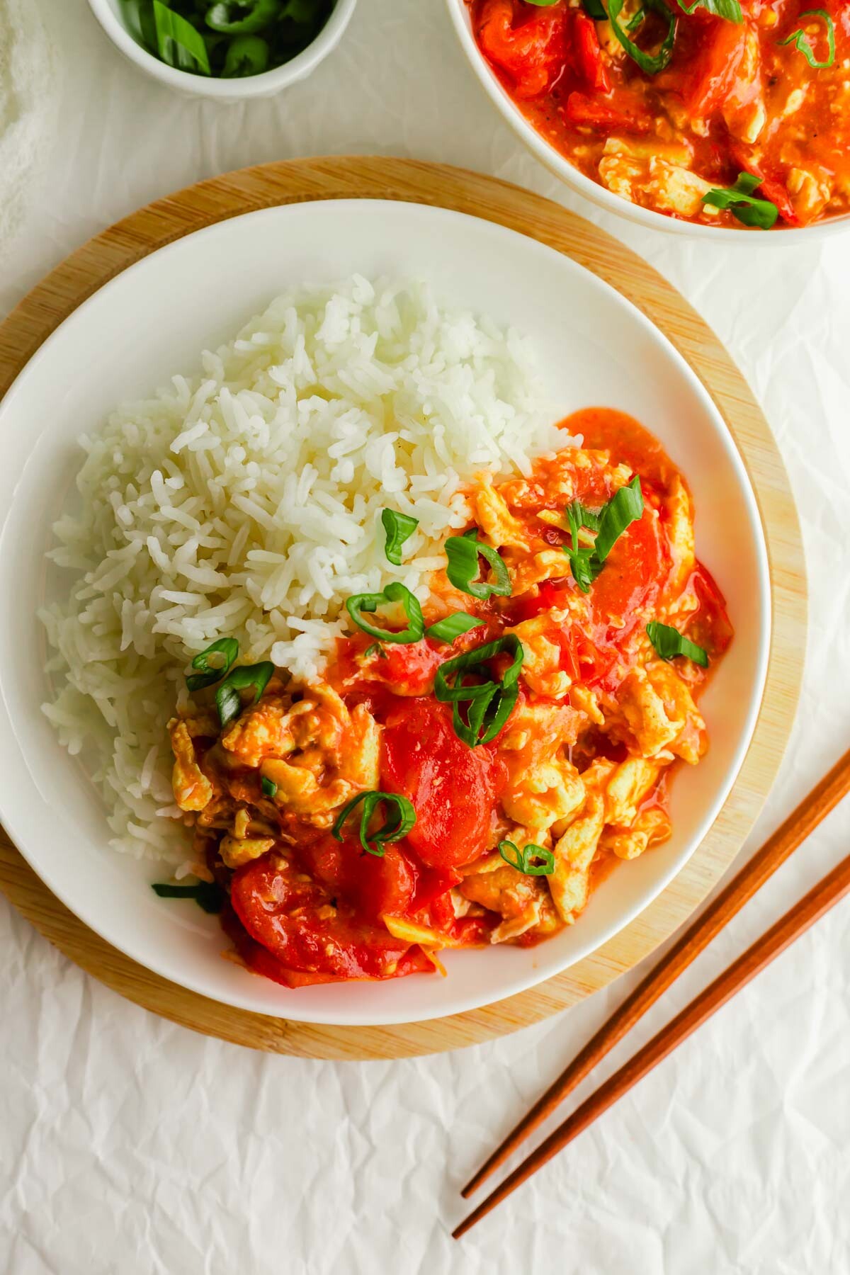 Chinese tomato egg with rice on a white plate.