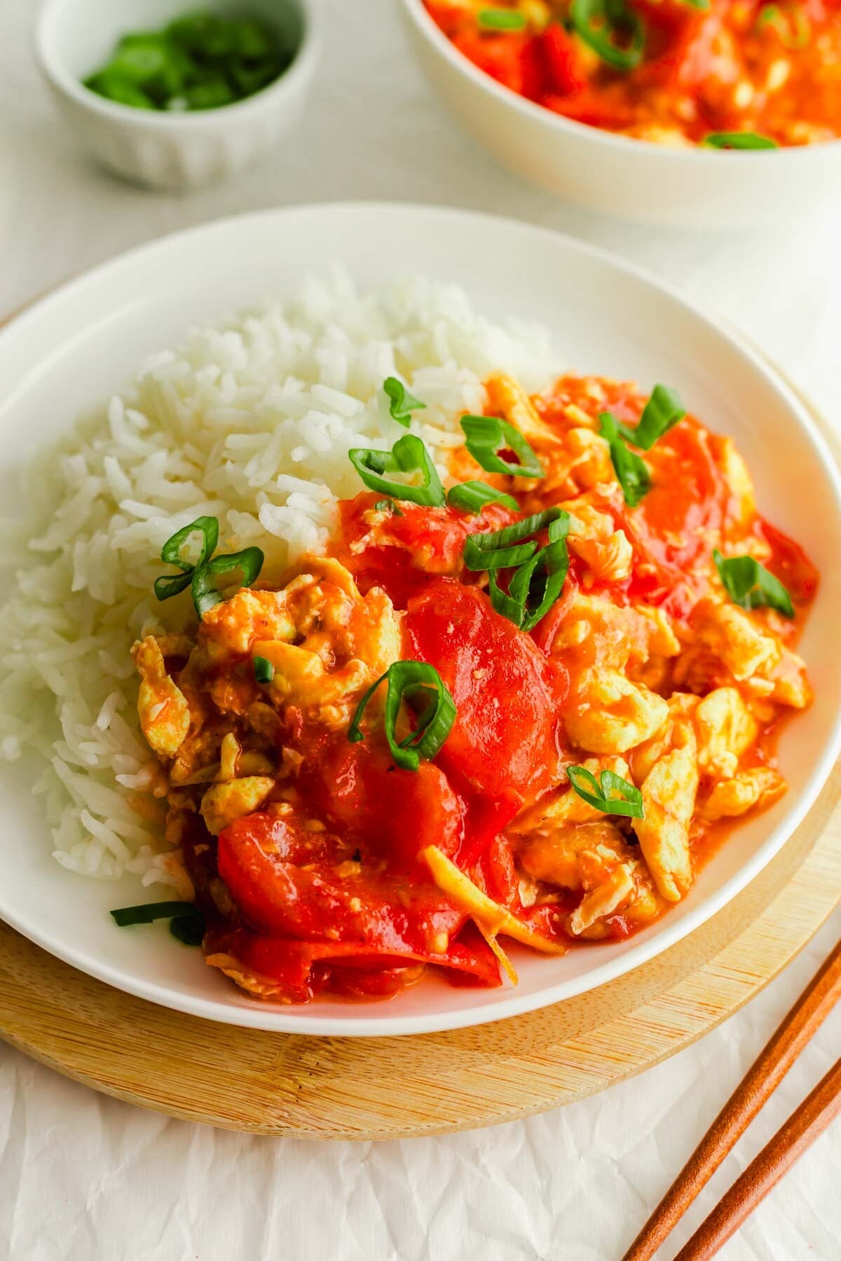 Chinese tomato egg with rice on a white plate.