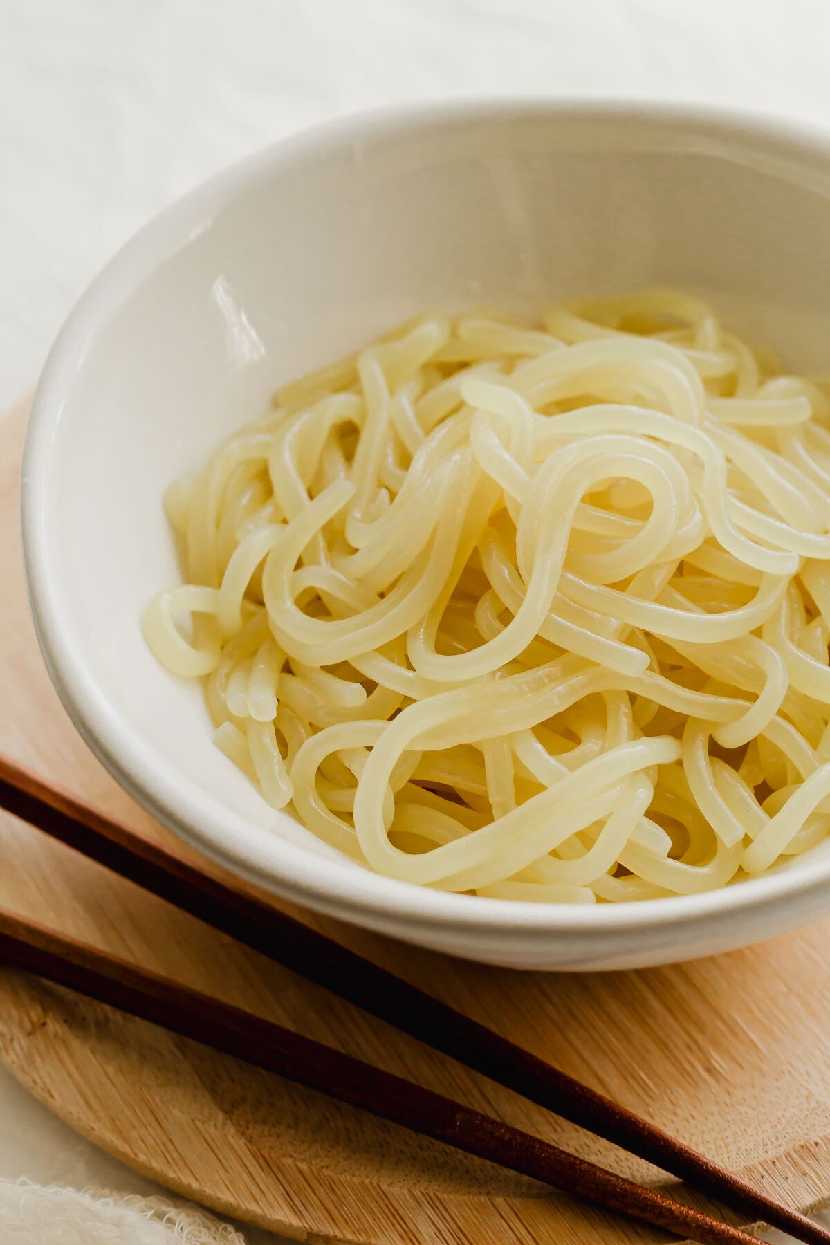A white bowl filled with Korean jjolmyeon noodles.