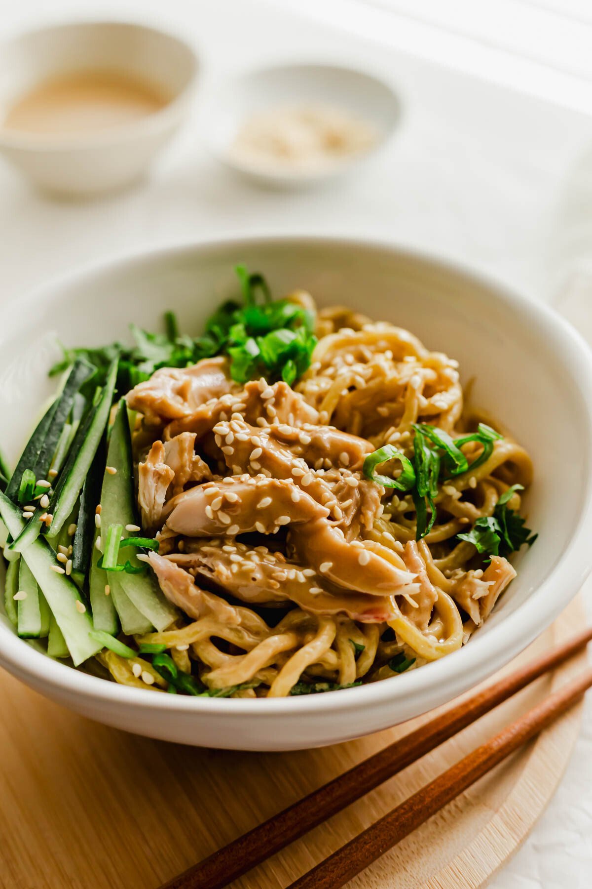 Chinese cold sesame noodles with chicken in a white bowl.