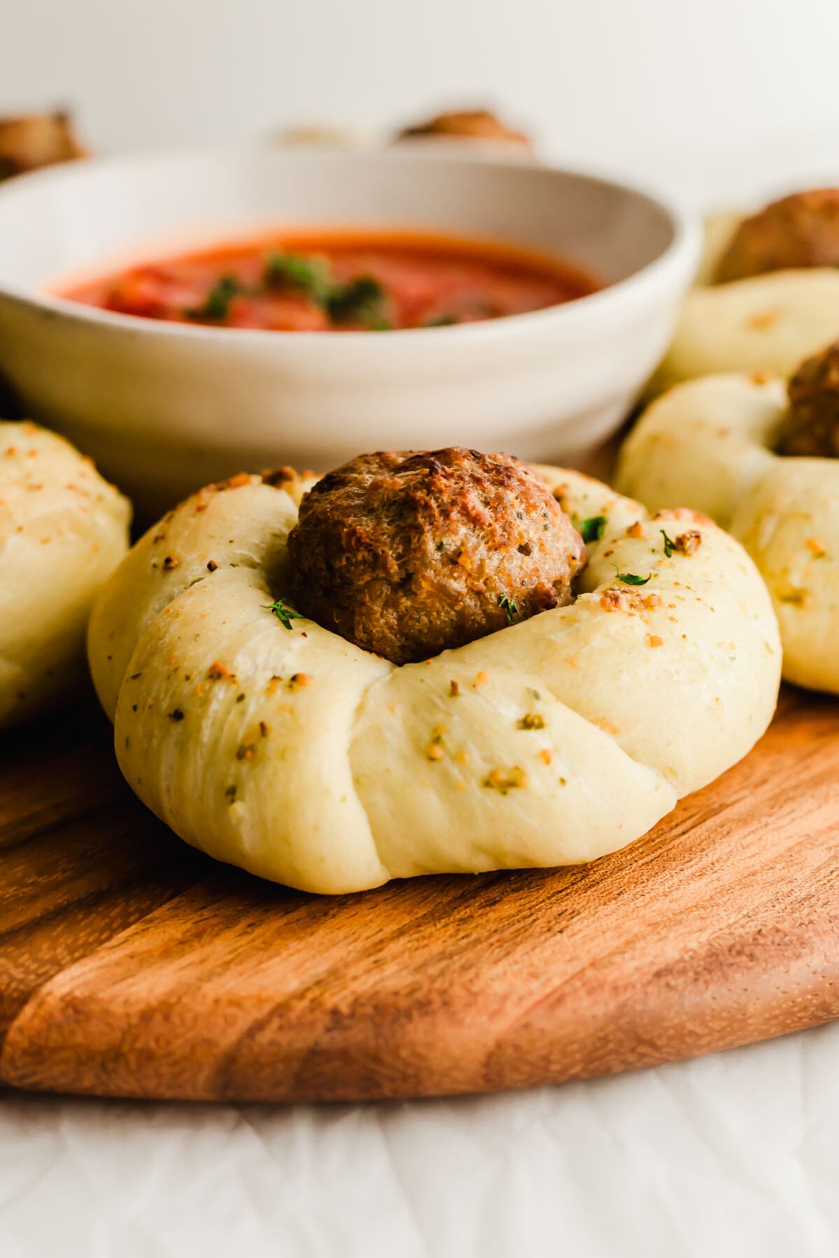 Close up of a garlic meatball knot on wooden board.