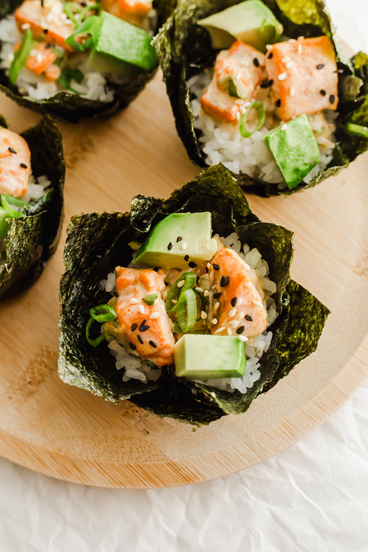 Baked salmon sushi cups on a wooden plate.