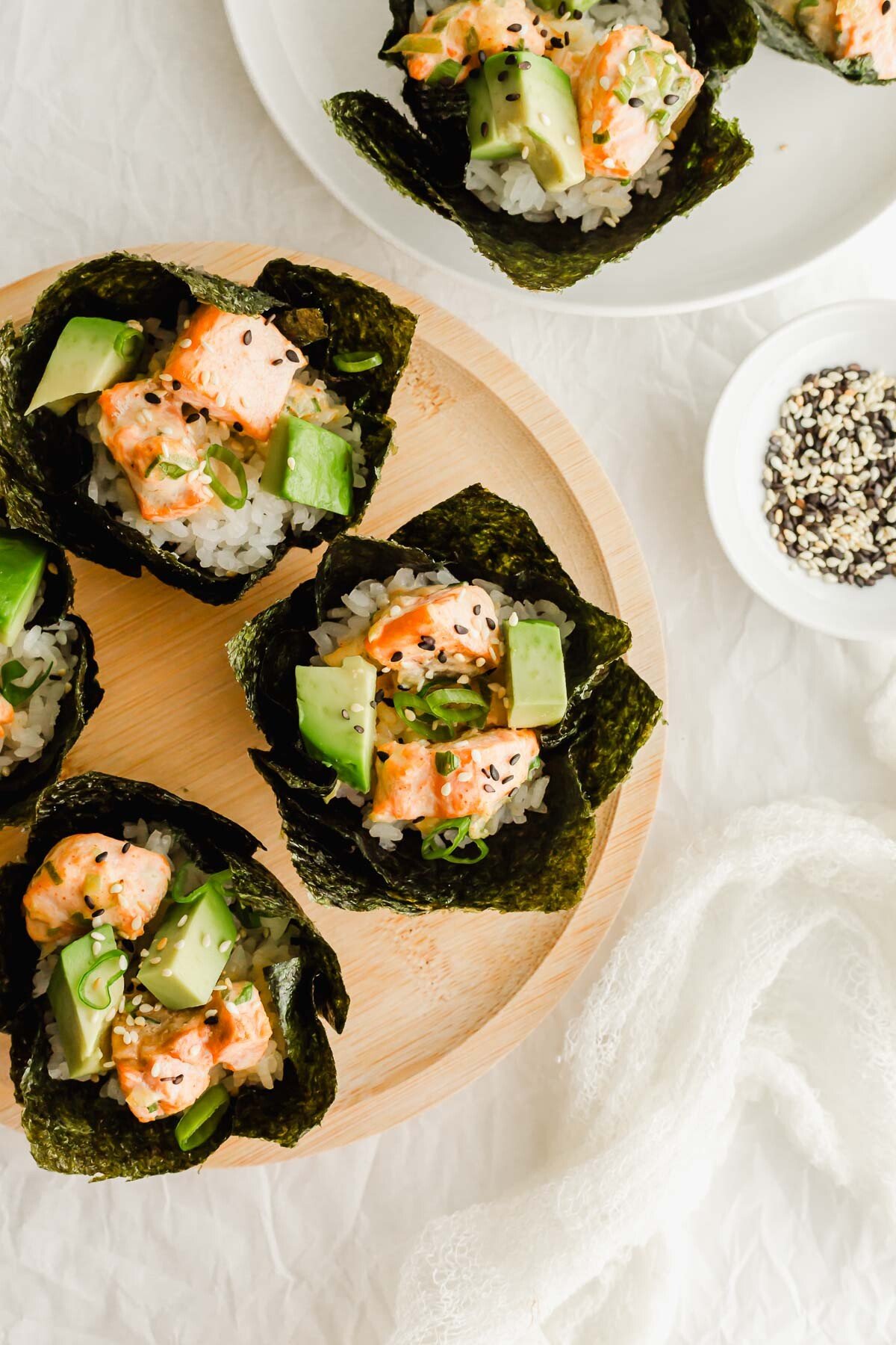 Baked salmon sushi cups on a wooden plate.