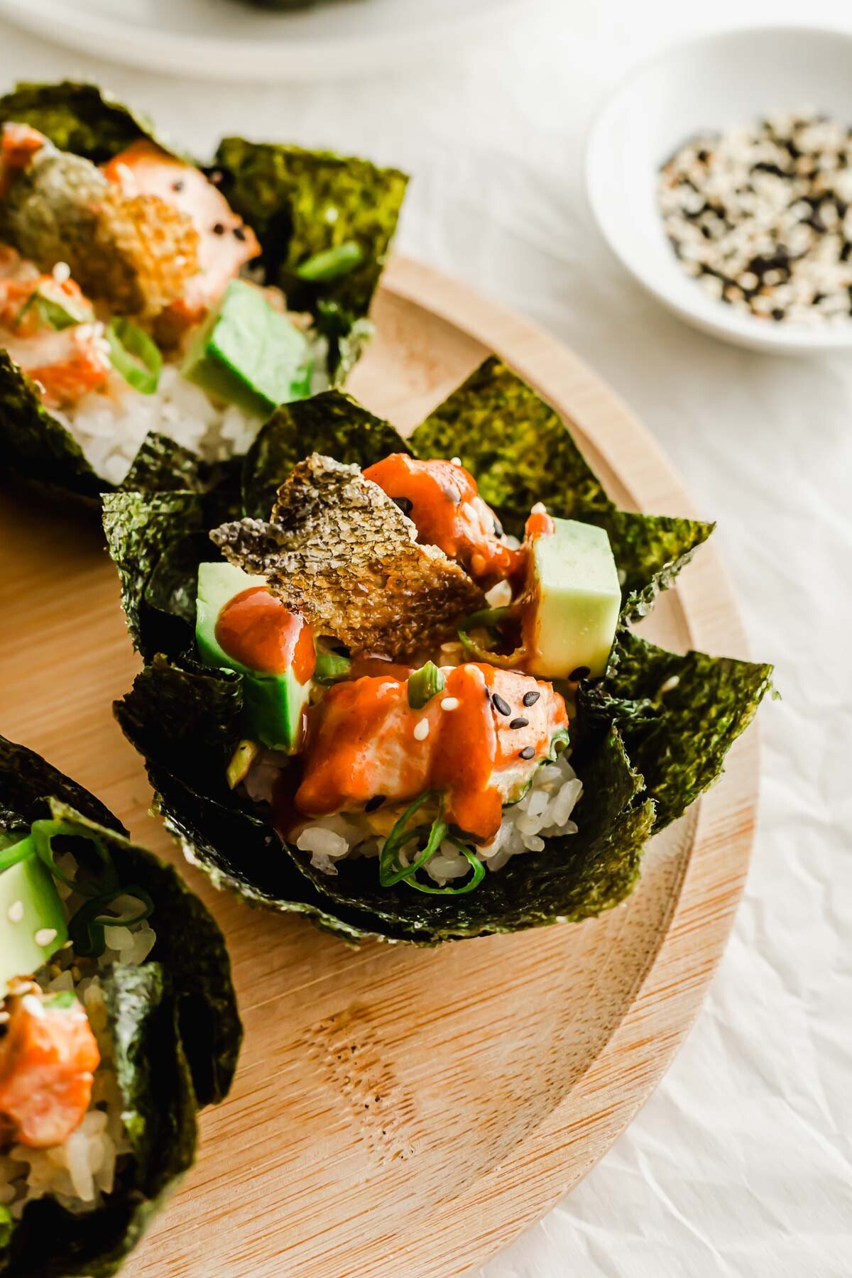 Baked salmon sushi cups on a wooden plate.