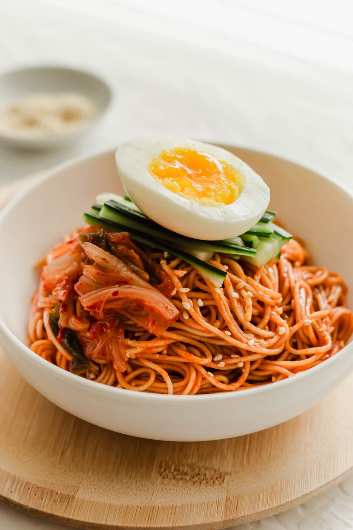 A white bowl filled with Korean bibim guksu noodles.